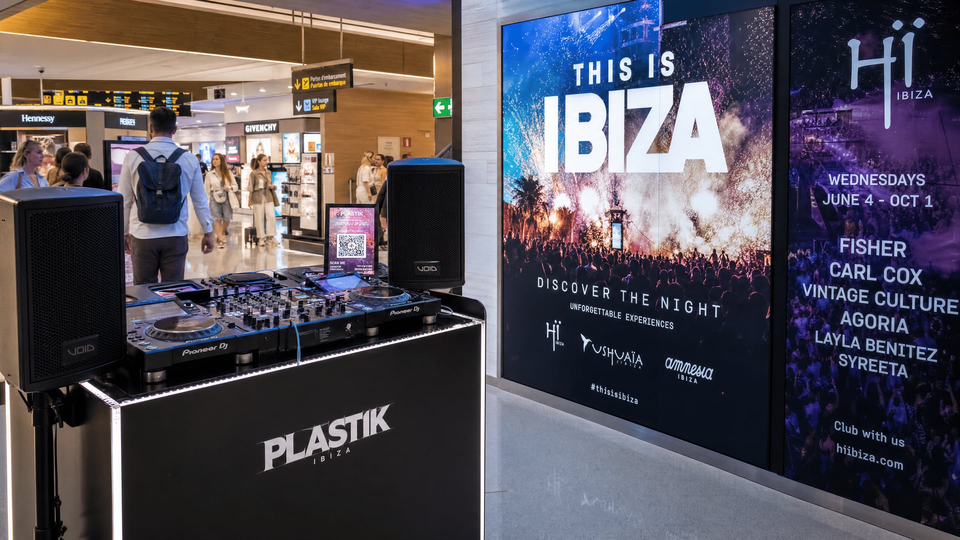 Ibiza Airport duty-free area showing a DJ setup beside discotheque advertising